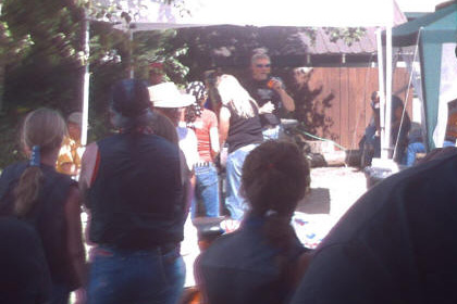 People standing at the event. A man speaks on microphone.