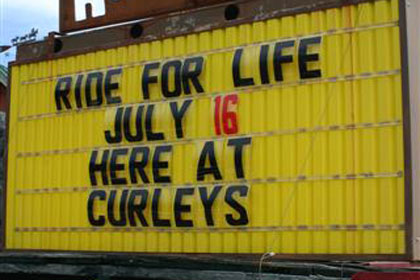 Yellow sign advertises event outside of Curley's.