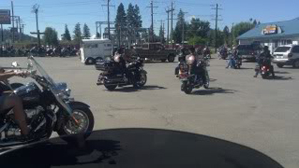 Riders on their motorcycles in the parking lot.