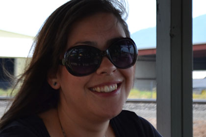 Woman wearing sunglasses smiles for the camera.