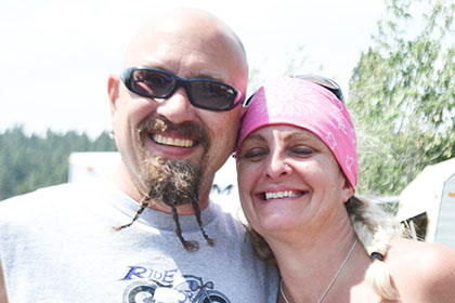 Man with a braided beard and a woman wearing a pink bandana.