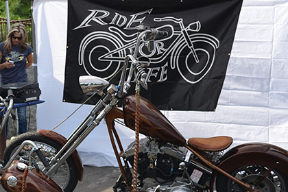 Two motorcycles on display in front of the Ride for Life logo banner.
