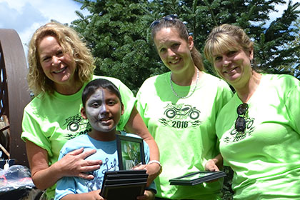 Three Ride for Life committee members and a child pose for a photograph.