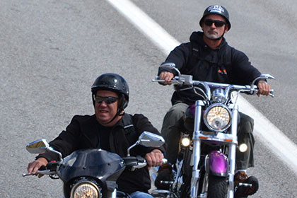 Two men riding their motorcyles.